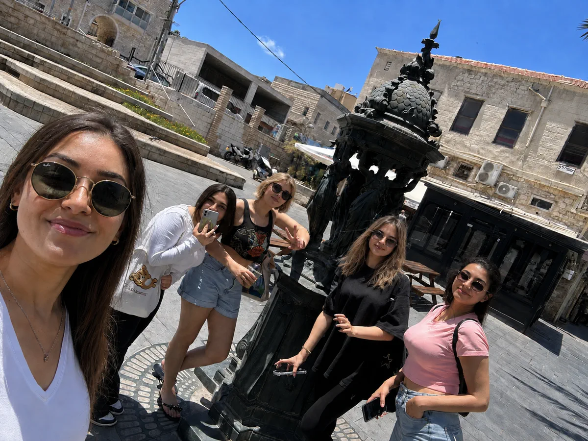 תמונה קבוצתית של משתתפי Quest City בכיכר בעיר התחתית בחיפה